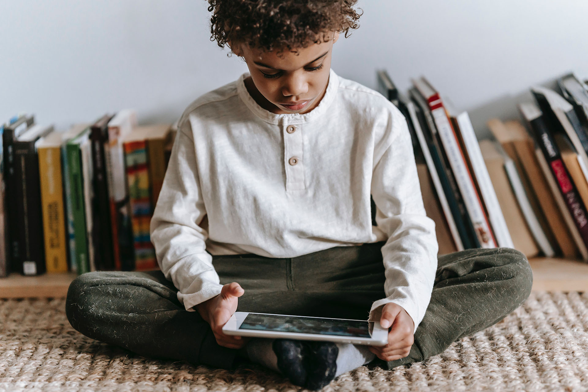 Picture of a boy using a tablet indoors.